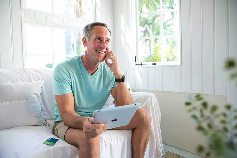 man in teal shirt taling on phone