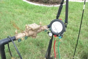 Backflow prevention system with multiple valves and pressure gauge installed in a residential lawn, ensuring safe water supply in Indianapolis, IN