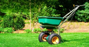 Green lawn spreader on a healthy, well-maintained lawn, emphasizing the importance of lawn fertilization for vibrant growth in Indianapolis