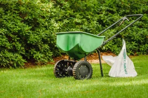 Lawn fertilizer spreader applying weed control treatment on a green Indianapolis lawn during the growing season