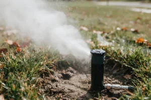 Close-up of a sprinkler head spraying water across a lawn, highlighting irrigation system winterization in Indianapolis.