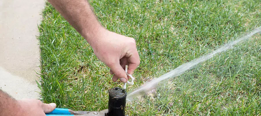 Man fixing broken sprinkler