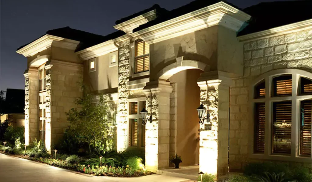 Elegant architectural lighting highlighting the exterior of a luxury stone home at night in Indianapolis