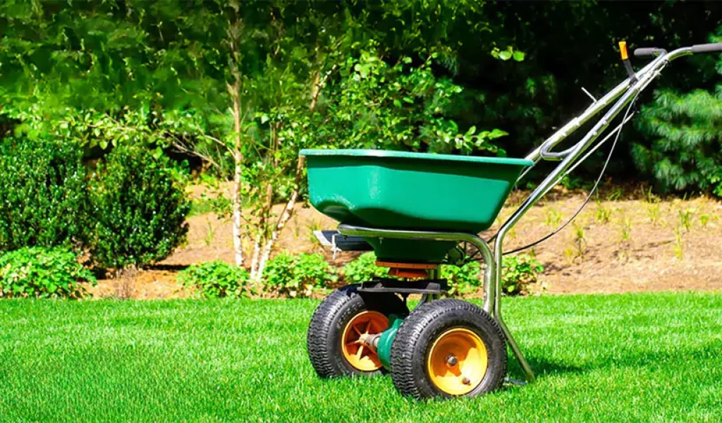 Green lawn spreader on a healthy, well-maintained lawn, emphasizing the importance of lawn fertilization for vibrant growth in Indianapolis