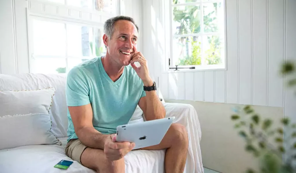 man in teal shirt taling on phone