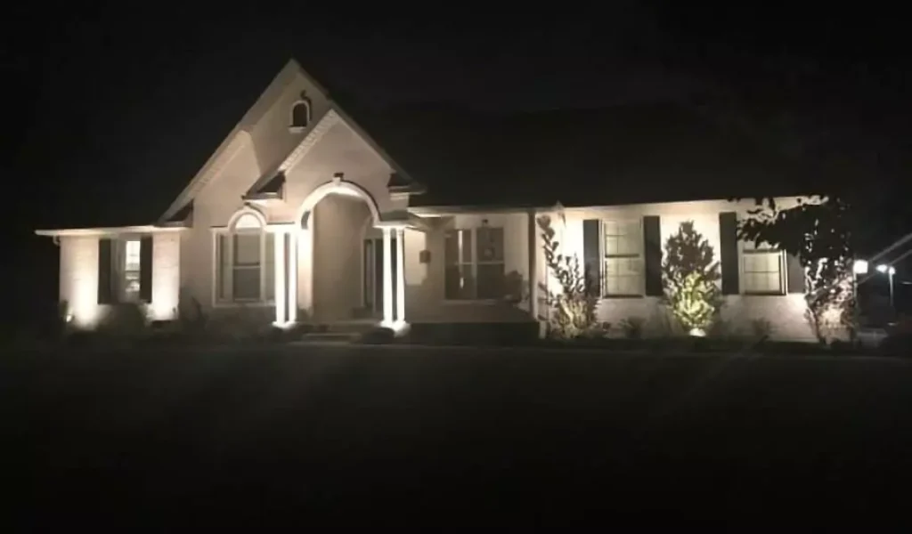 house lit up at night with landscape lighting