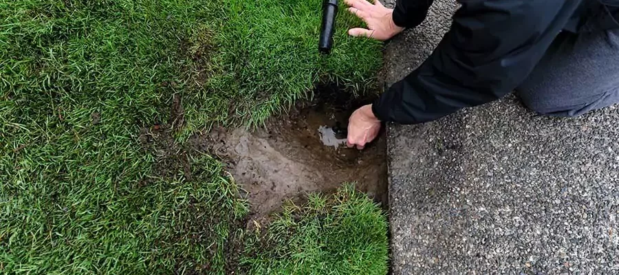Man fixing a sprinkler that is broken
