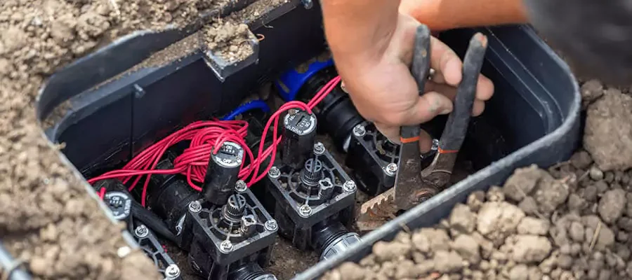 two Hands repair sprinkler valve systems